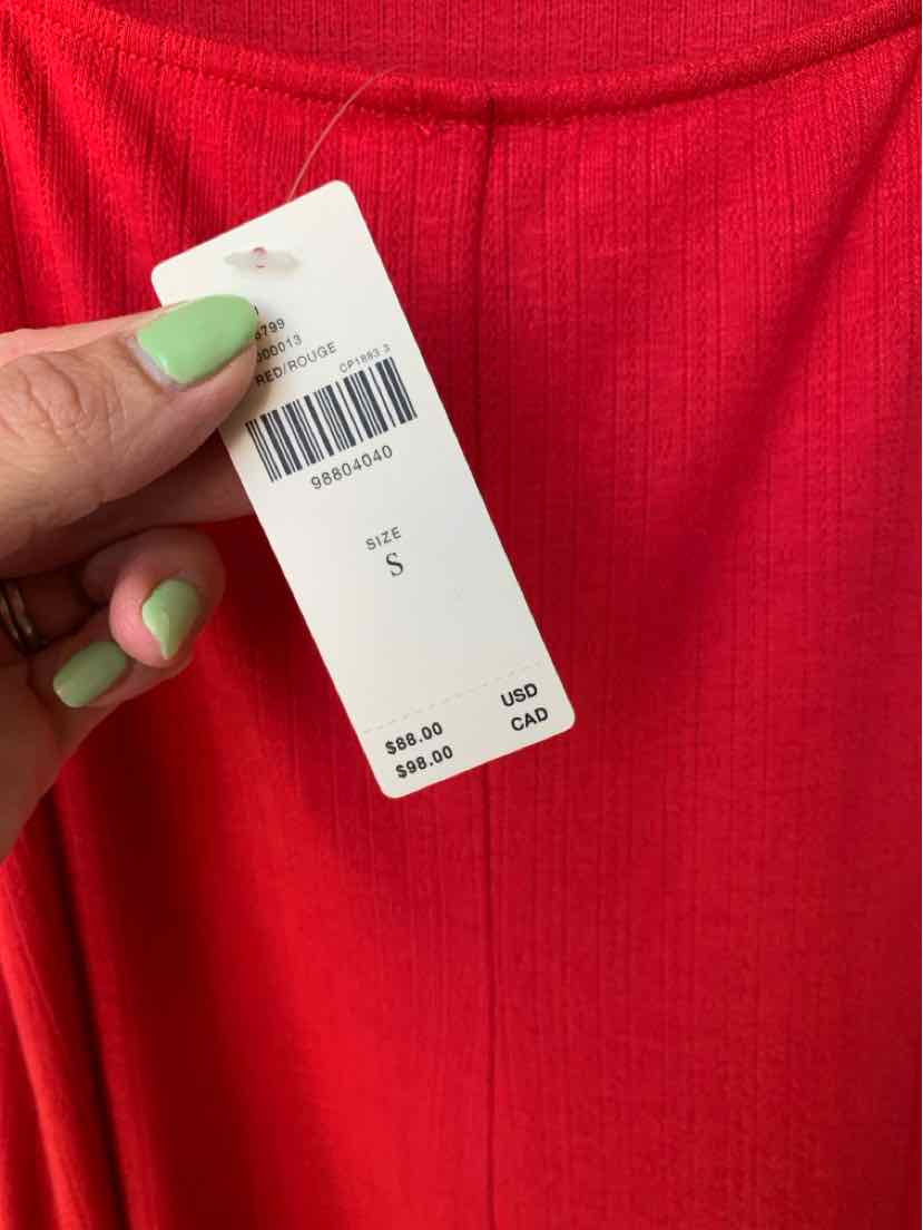 Bright red ribbed fabric dress with a smooth texture and small size tag attached.