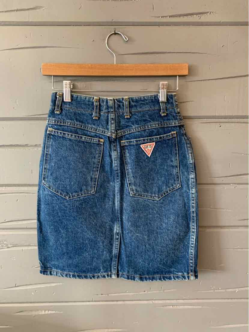 Blue denim skirt with back pockets and Guess logo patch, knee-length, size 4.