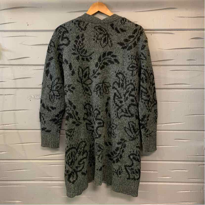 Gray knitted cardigan with black floral pattern and long sleeves hanging on wooden hanger.