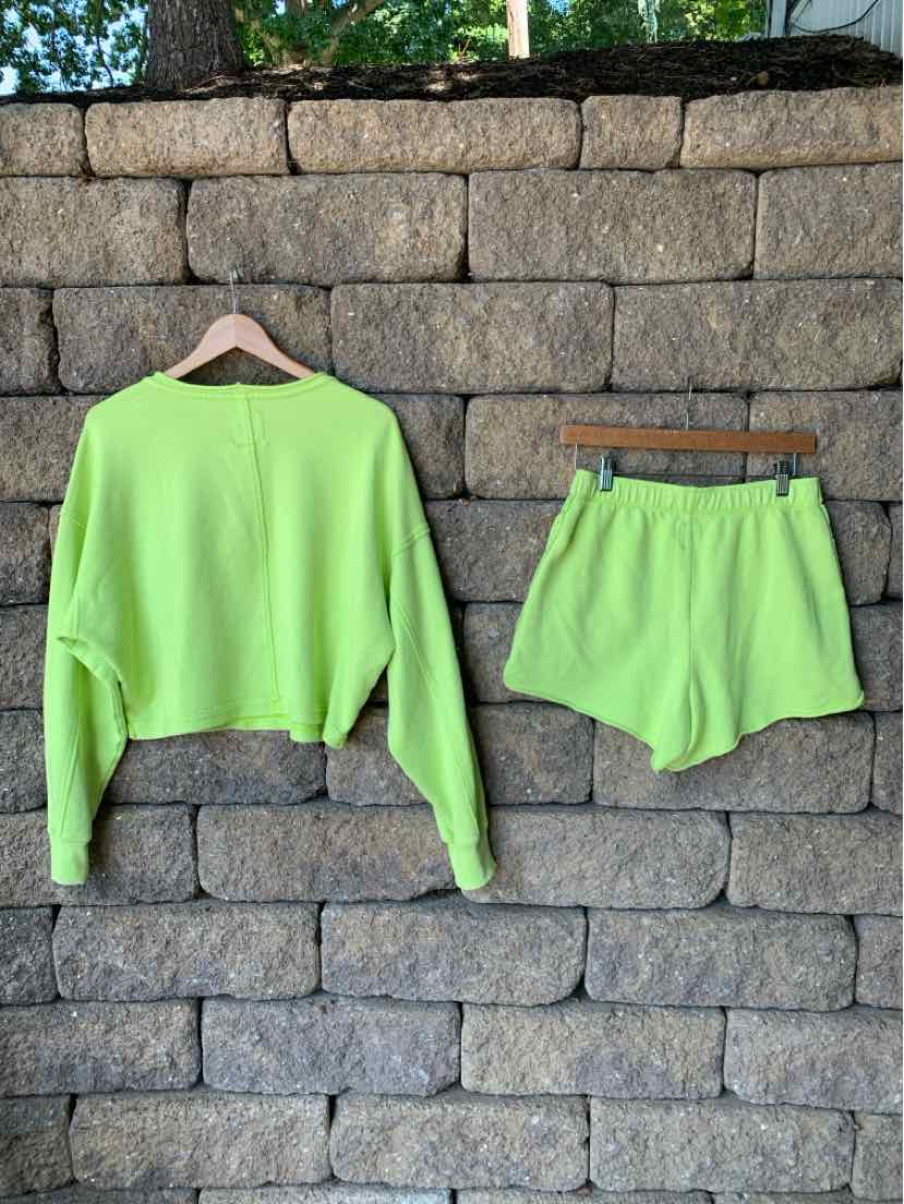 Neon green long-sleeve cropped sweatshirt with matching high-waist elastic shorts, soft fabric.