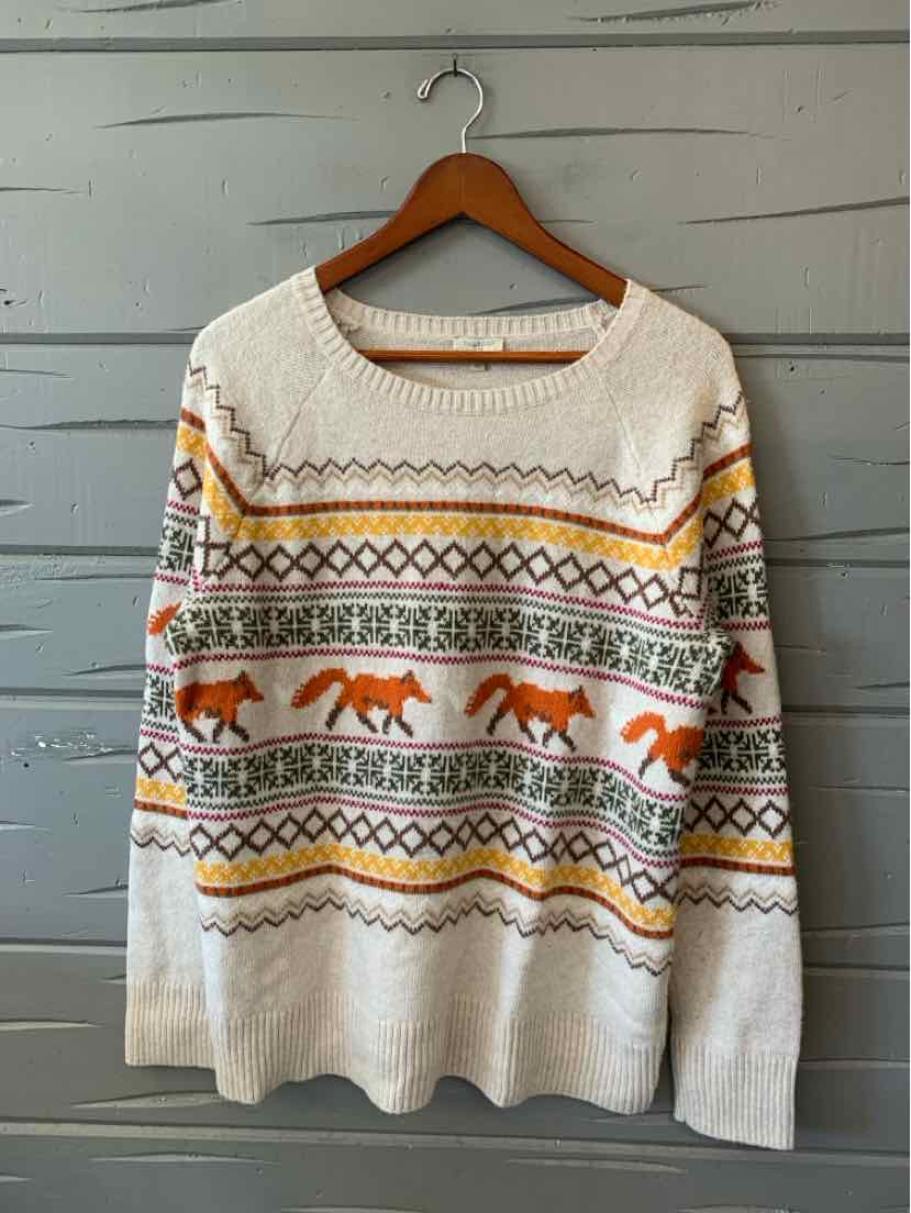 Cream Talbots knit sweater with colorful geometric bands, orange animal motifs, and ribbed trim on a wooden hanger.