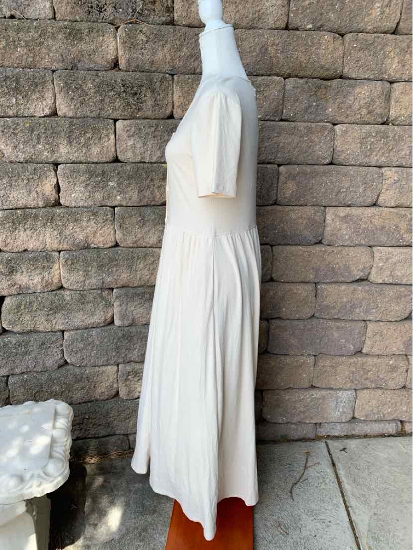Light beige midi dress with short puff sleeves and a cinched waist, lightweight fabric.