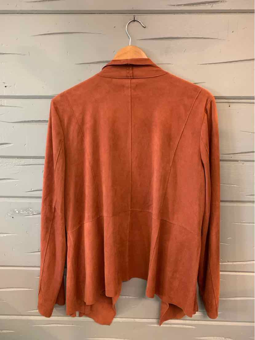 Rust-colored suede jacket with long sleeves and relaxed fit, hanging on wooden hanger.