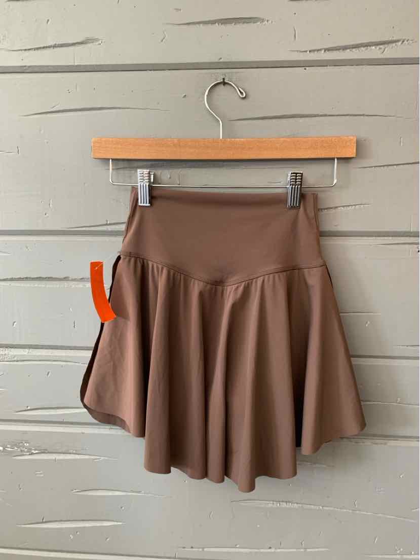Brown high-waist flared skirt with wide waistband and soft, lightweight fabric hanging on wooden hanger.