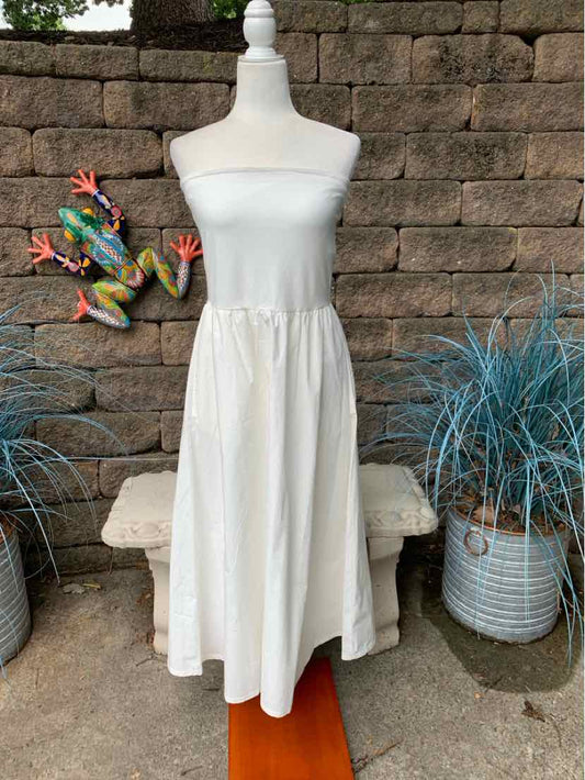 White strapless midi dress with elasticized waist and flowy skirt on mannequin.