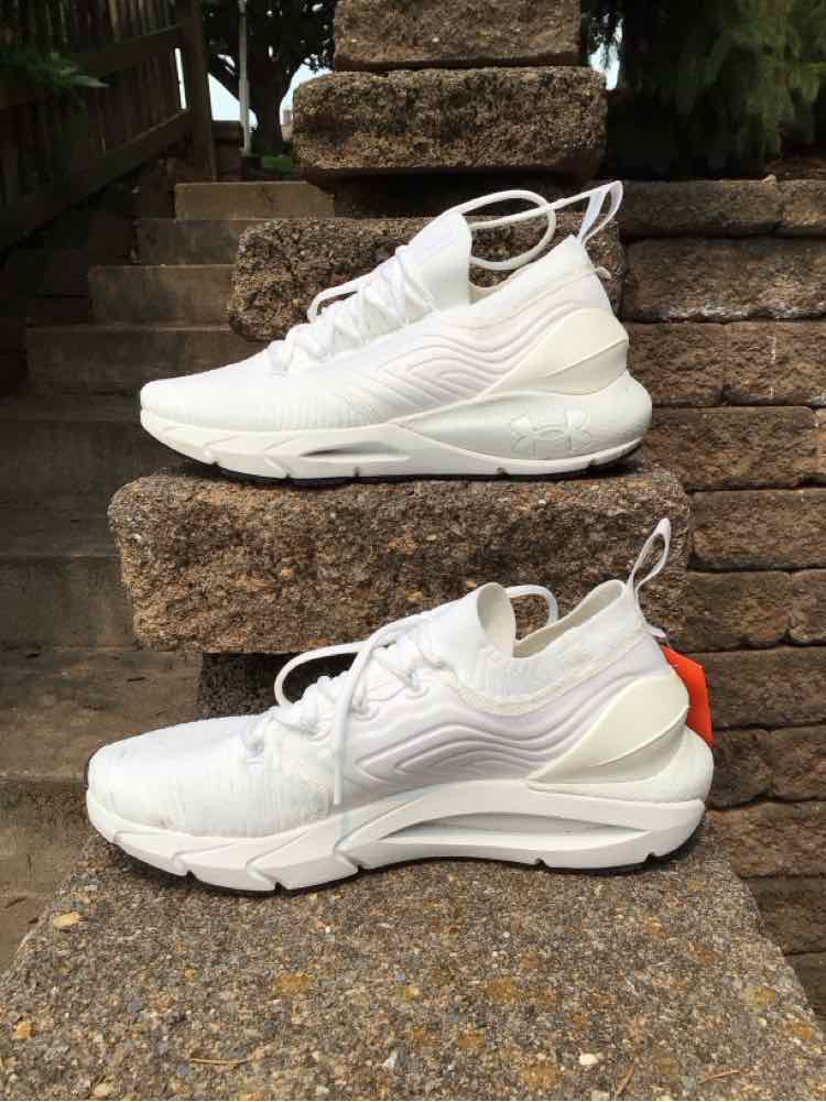 White Under Armour women's sneaker size 9.5 with mesh and synthetic upper, cushioned sole, and heel pull tab.