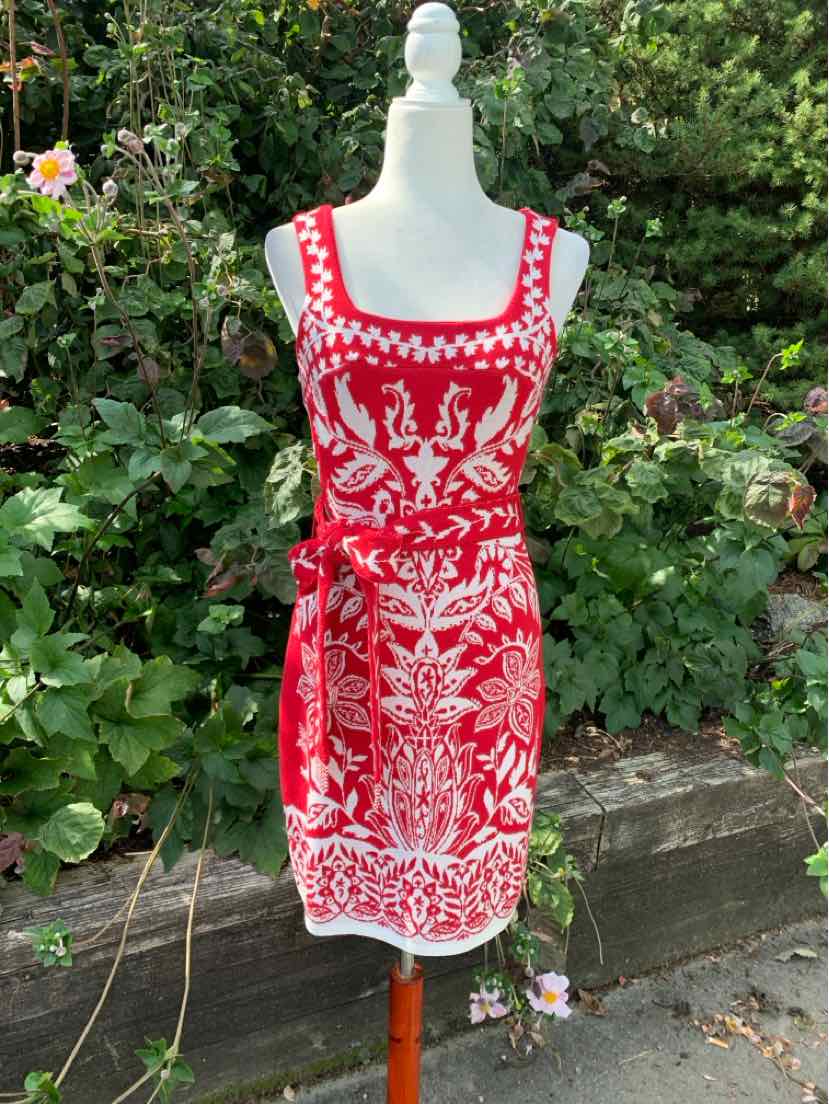 Red sleeveless dress with white paisley and floral print, square neckline, and waist tie belt.