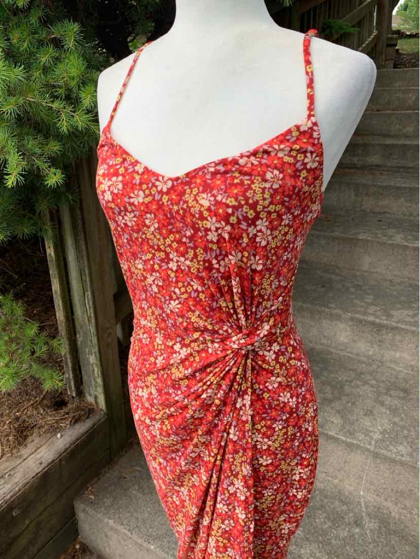 Red floral spaghetti strap dress with ruched side detailing and fitted silhouette.