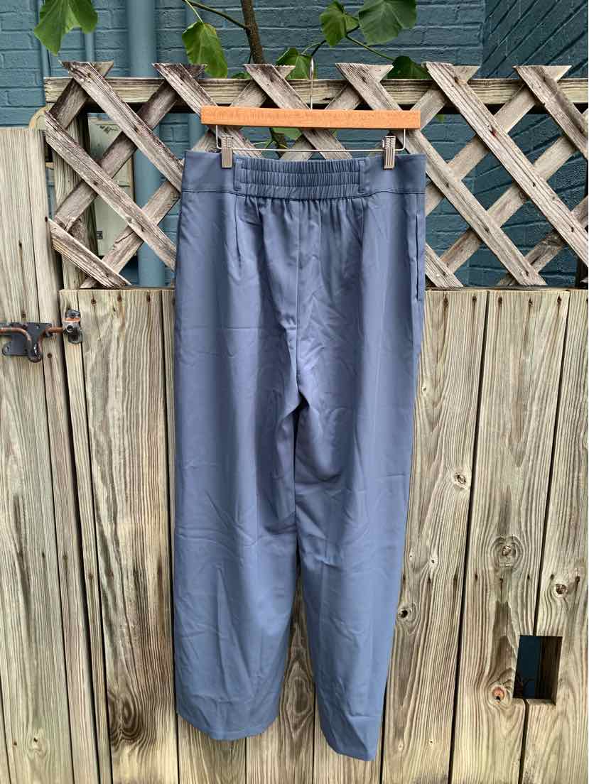 Blue high-waist jogger pants with elastic waistband and tapered legs hanging on wooden hanger.