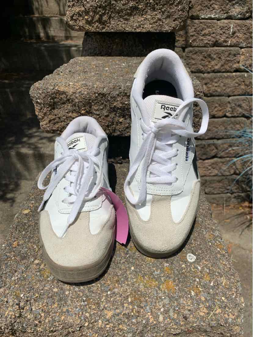 White Reebok sneakers with beige suede toe caps, white laces, and cushioned collars.