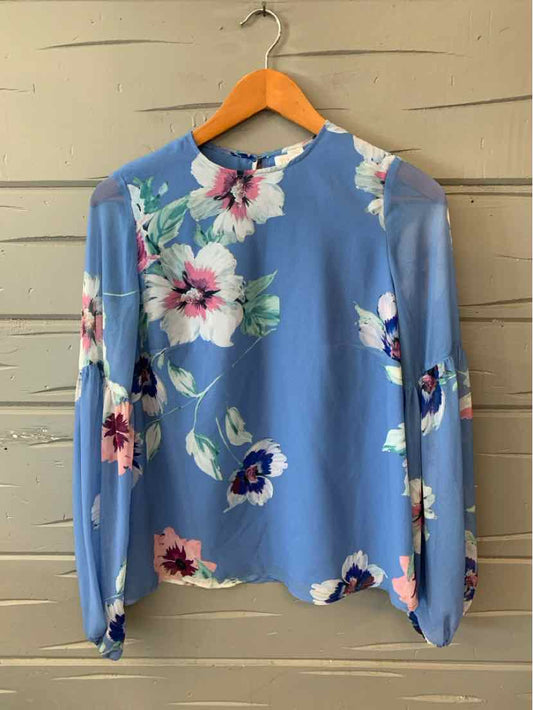 Blue blouse with pink and white floral print, long puff sleeves, crew neckline, and lightweight fabric.