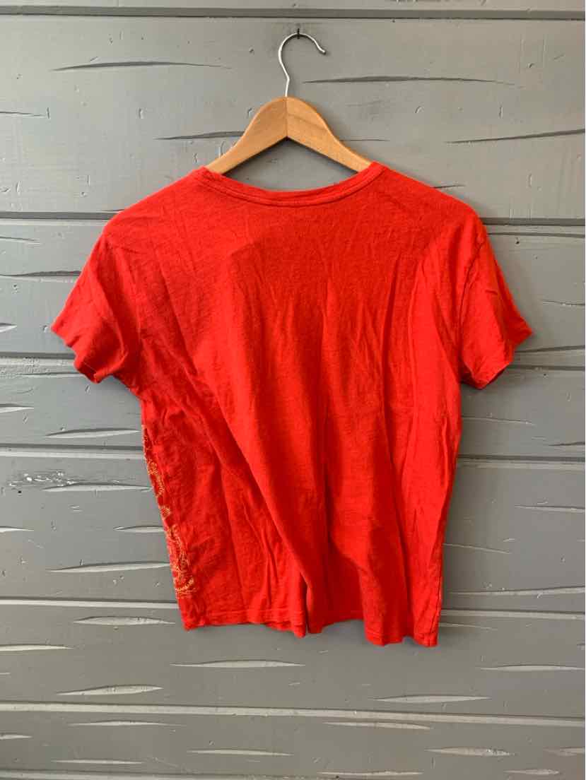 Red short-sleeve T-shirt with a crew neckline on a wooden hanger against a gray wooden background.