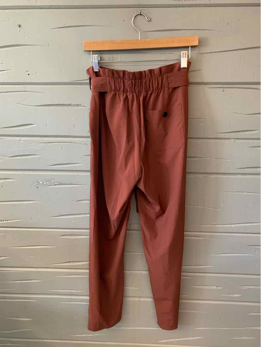 Women's burgundy tapered pants with elastic waistband and side pockets in size 6.
