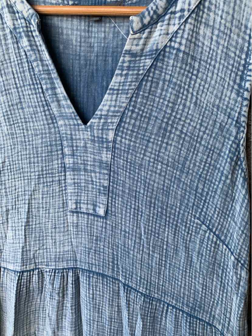 Blue chambray dress with textured grid pattern, V-neckline, and gathered waist detail.