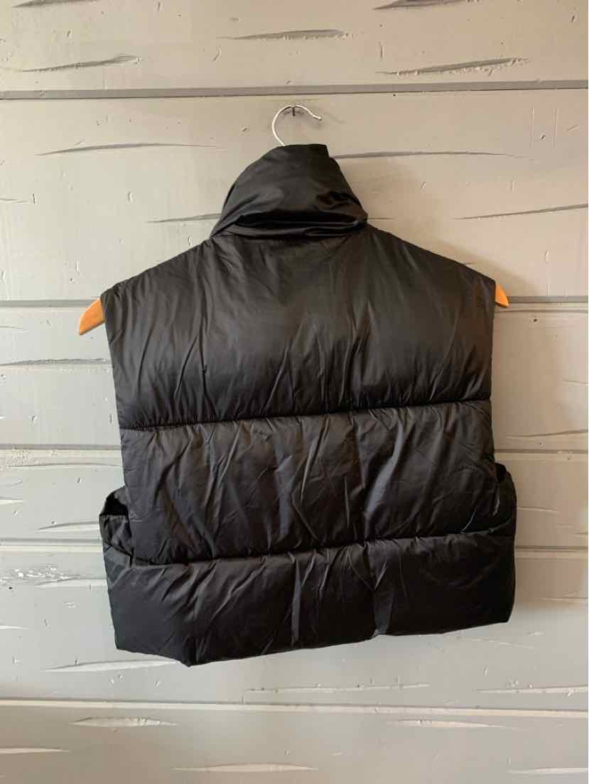 Black puffer vest with high collar and horizontal quilting in size XS hanging on wooden hanger.