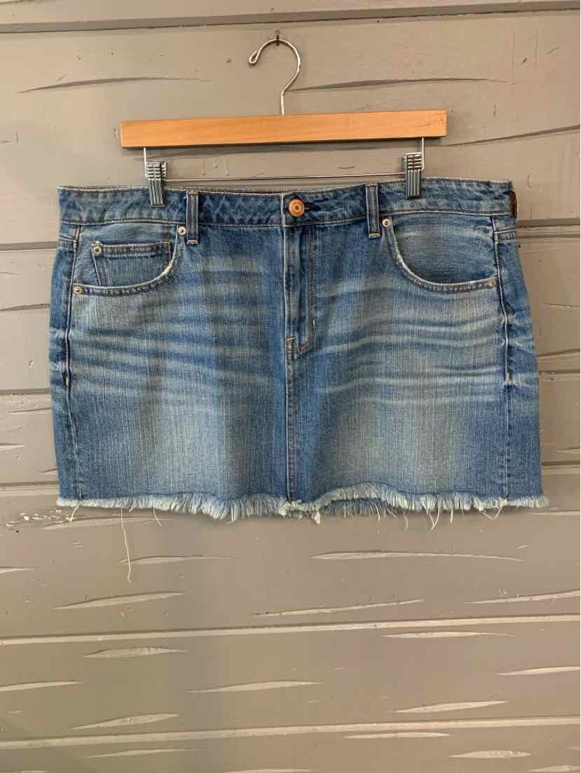 Denim mini skirt in medium blue wash with frayed hem and classic five-pocket design.