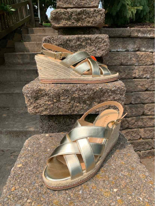 Wedge heel sandal with metallic gold crisscross straps and ankle buckle, size 8.5.
