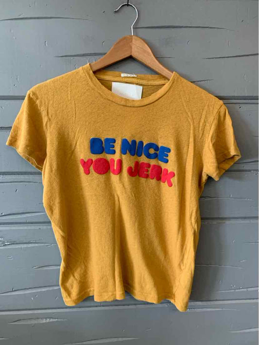 Mustard yellow short-sleeve cotton t-shirt with blue and red raised lettering saying "BE NICE YOU JERK".