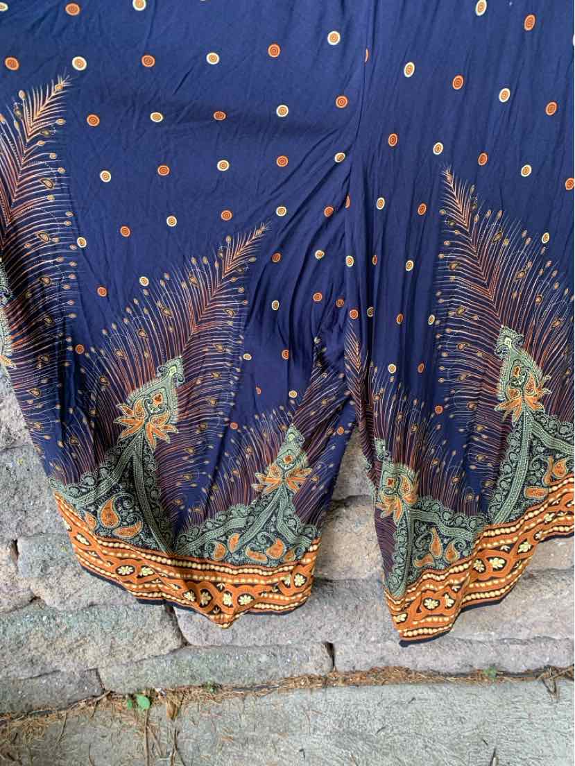 Navy blue fabric with scattered orange dots, detailed with ornate orange, green, and beige floral patterns along the hem.