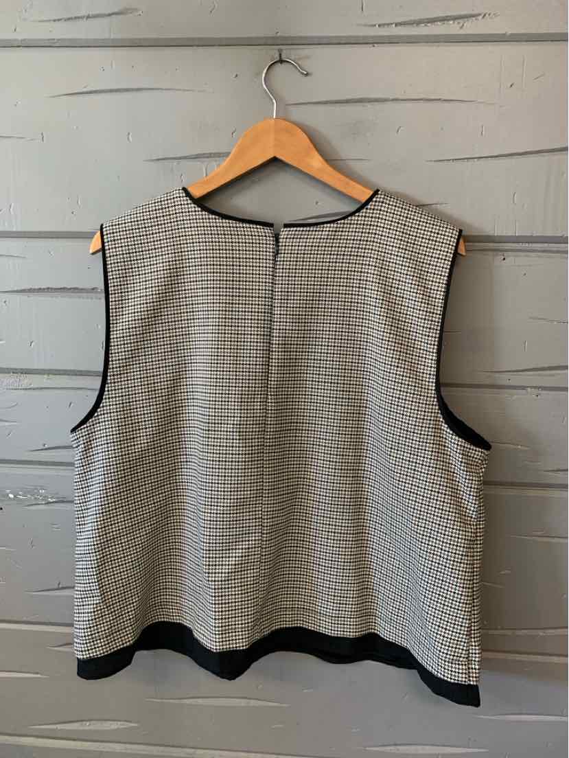 Black and white houndstooth sleeveless top with black trim, size XXL, hanging on wooden hanger.