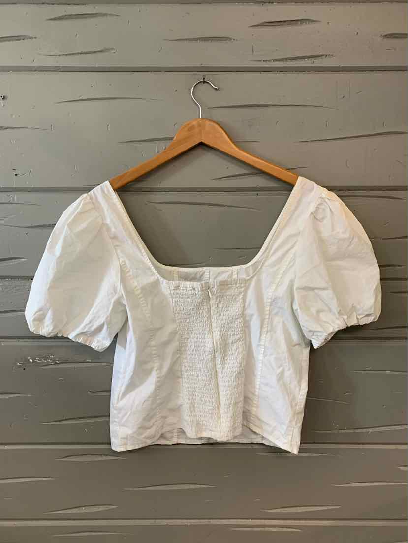 White puff-sleeve blouse with square neckline and fitted waist on wooden hanger.