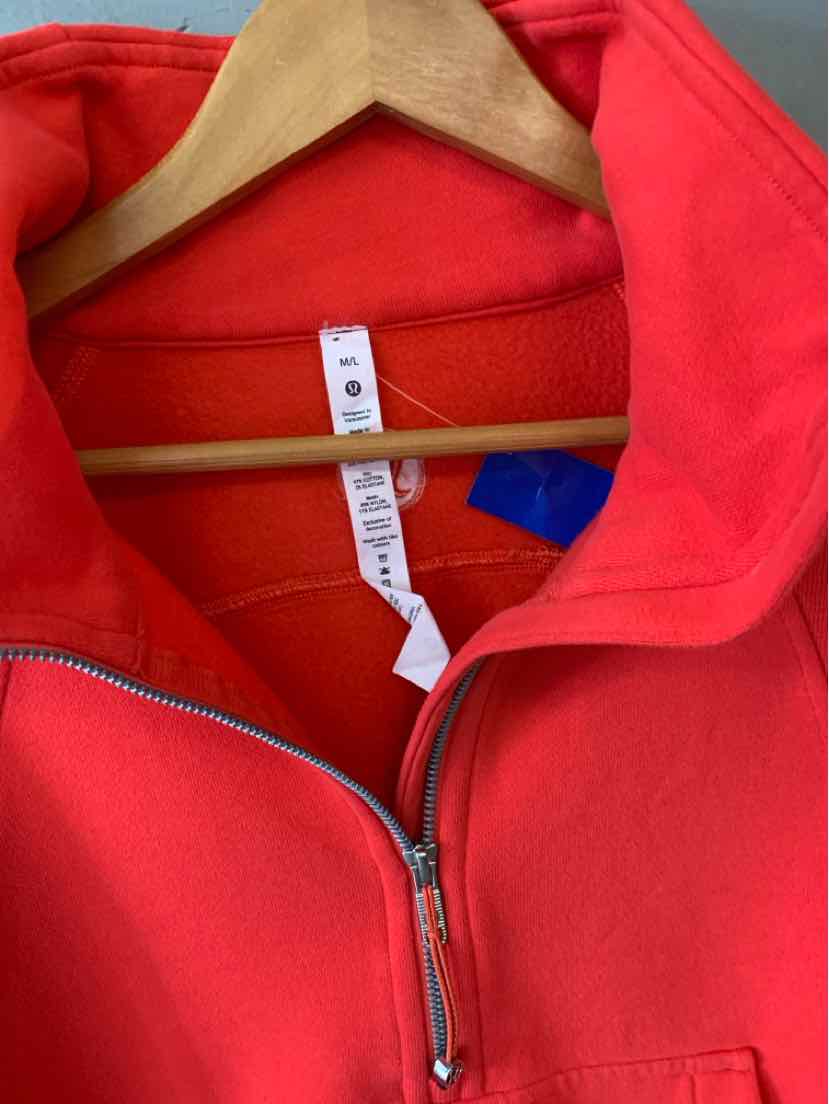 Bright red Lululemon zip-up jacket with a stand collar, teal-trimmed pockets, and size M/L tag.