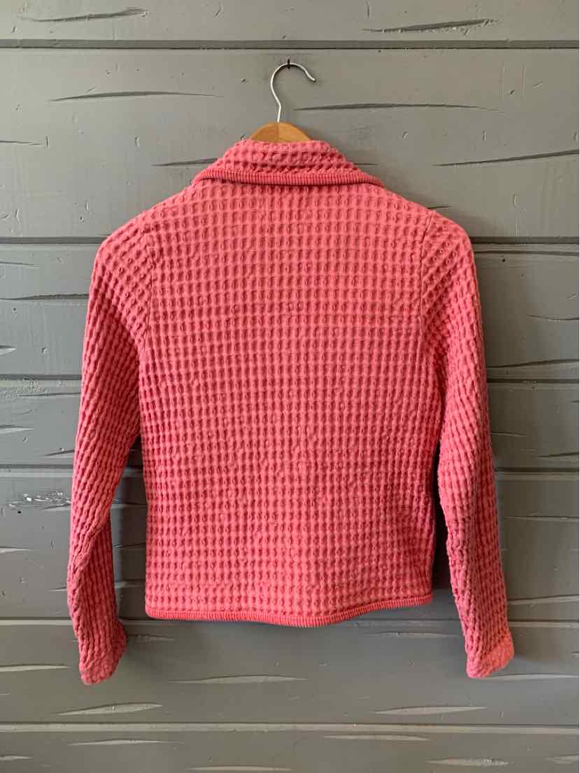 Pink waffle knit long-sleeve jacket with collar and cropped hem hanging on wooden hanger.