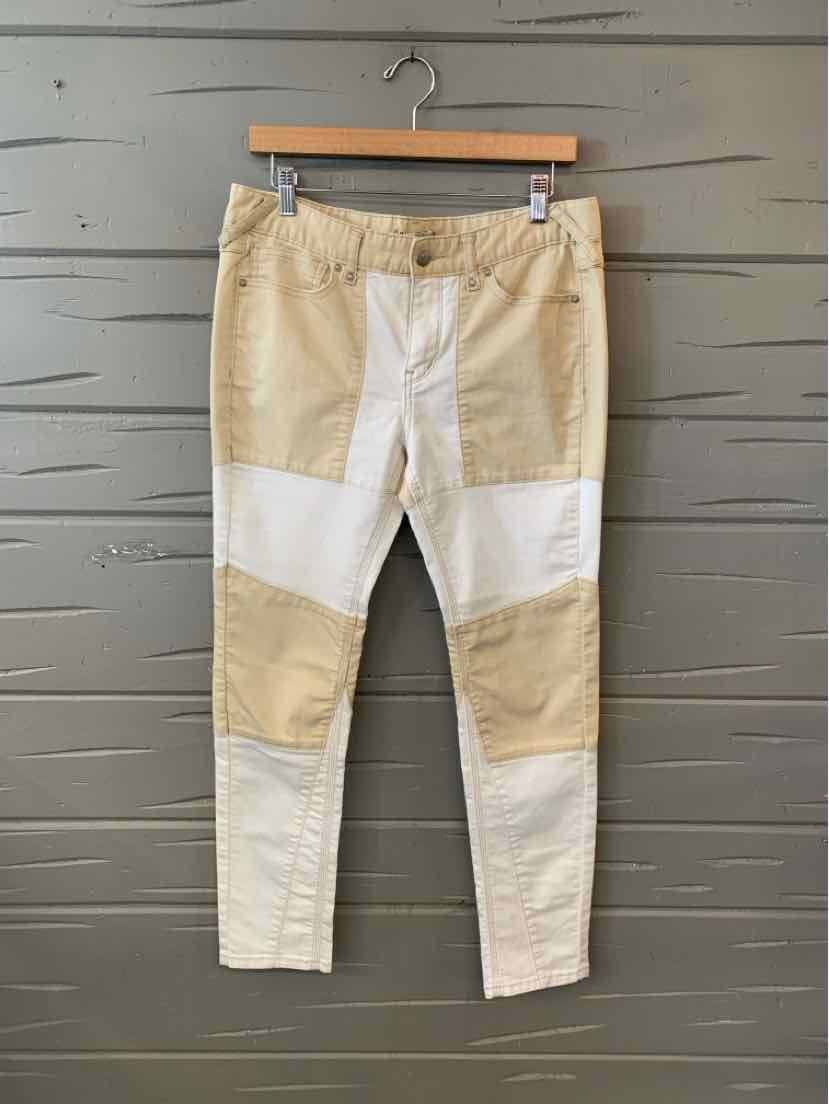 Tan and white color block pants with patchwork design, slim fit, and visible stitching details.