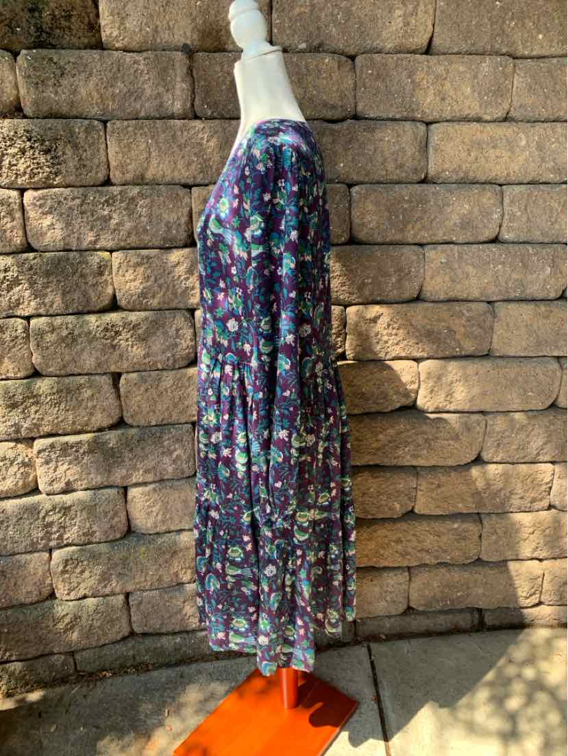 Midi-length dress with long sleeves, dark base color, and multicolored floral print.