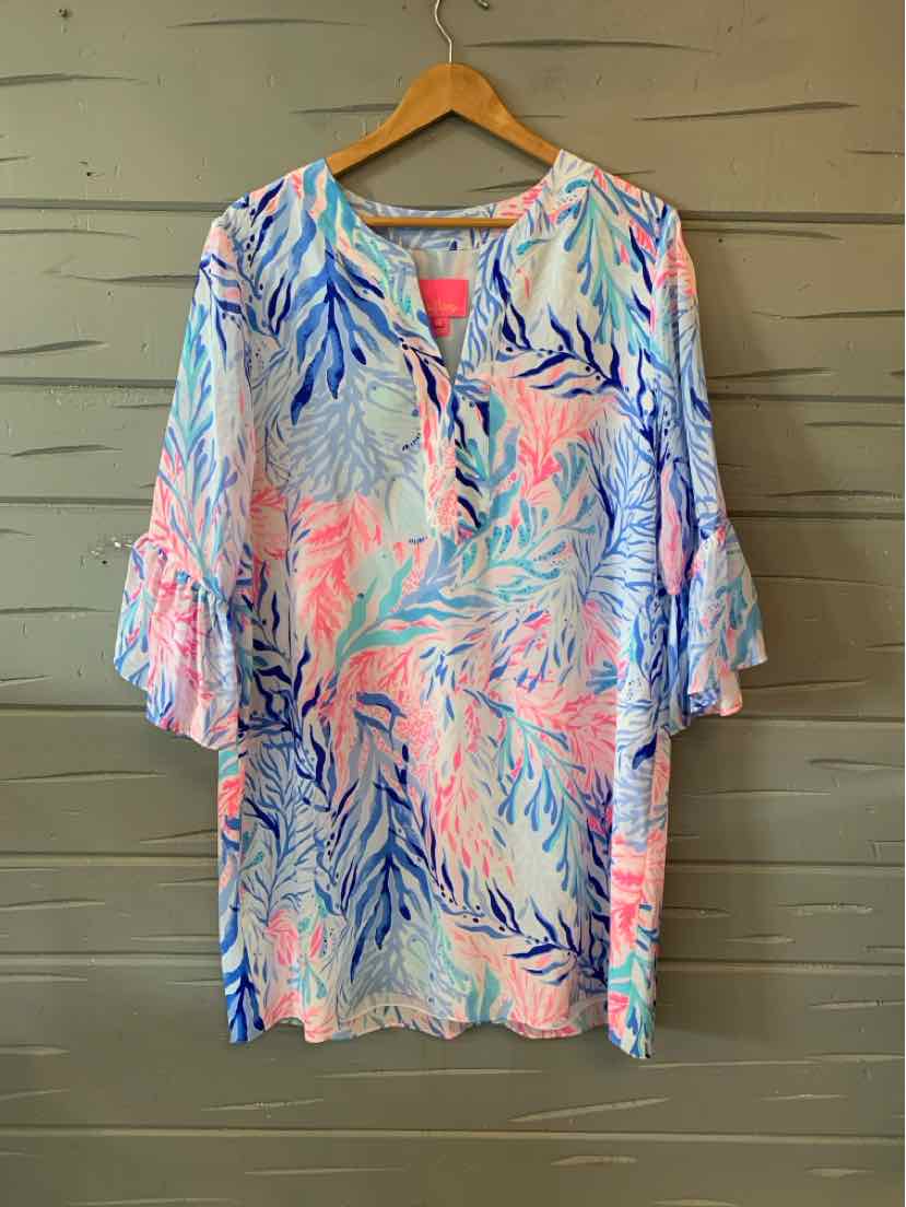 Colorful oversized tunic with blue, pink, and purple tropical leaf print, V-neck, and flared sleeves.