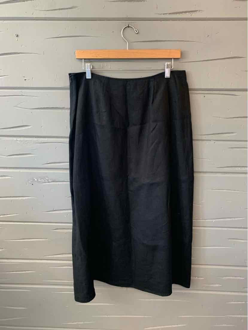 Black midi skirt with straight silhouette, subtle seam details, and smooth fabric hanging on wooden hanger.