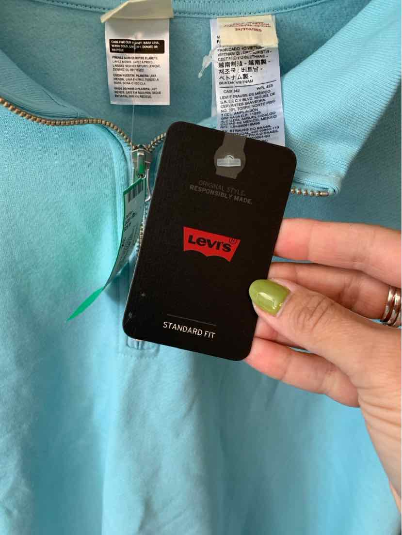 Light blue Levi's zip-up garment with silver zipper and black Levi's tag held in hand.