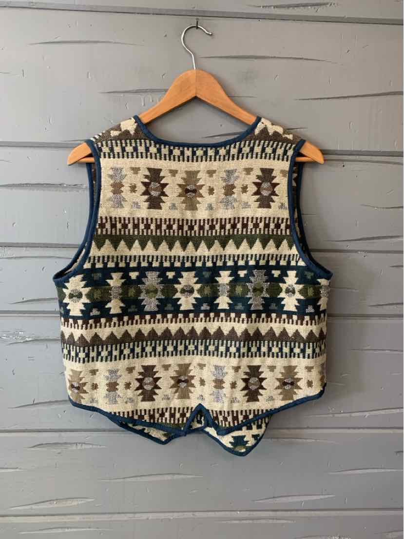 Women’s sleeveless multicolor knit vest with geometric Aztec patterns, navy trim, and a pointed hem.