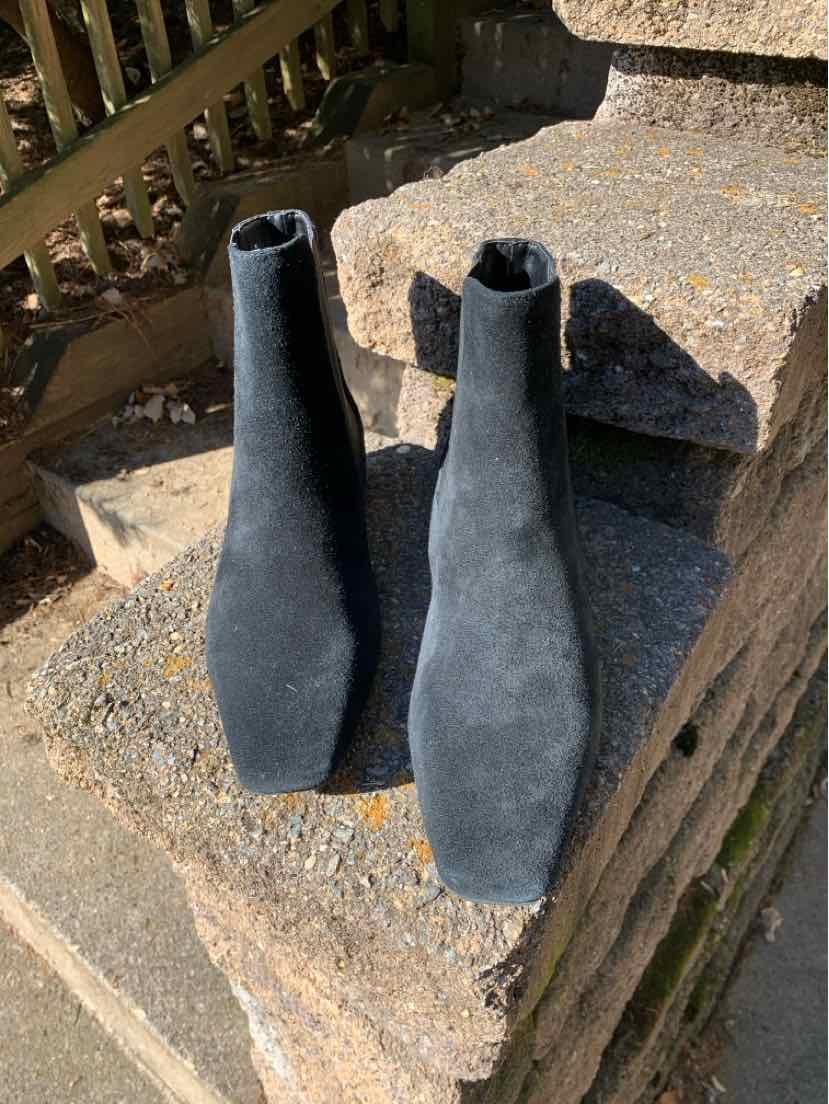 Pair of black suede ankle boots with pointed toes, slim shafts, and low stacked heels.