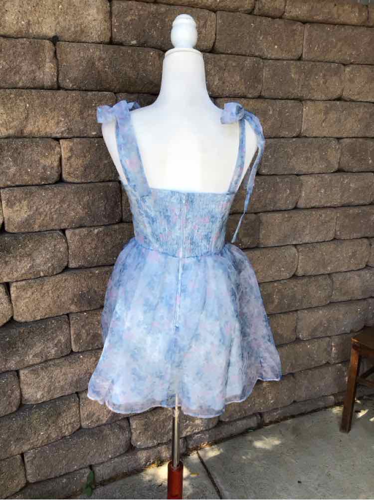 Light blue floral mini dress with thin adjustable shoulder straps and fitted waist.