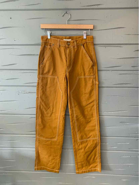Mustard yellow high-waisted pants with front patch pockets and visible seam detailing.