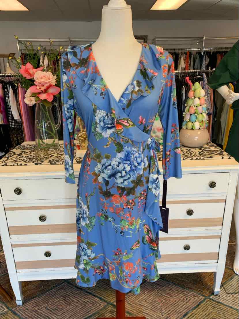 Blue floral wrap dress with 3/4 sleeves and V-neck on mannequin.
