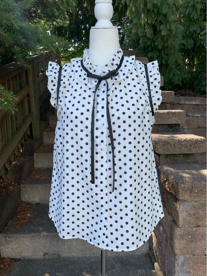 White sleeveless blouse with black polka dots and a black tie neck bow, loose fit.