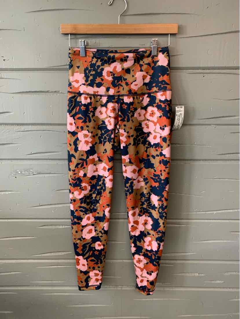 Floral print leggings with pink, orange, and black flowers on a navy background, high-waisted fit.