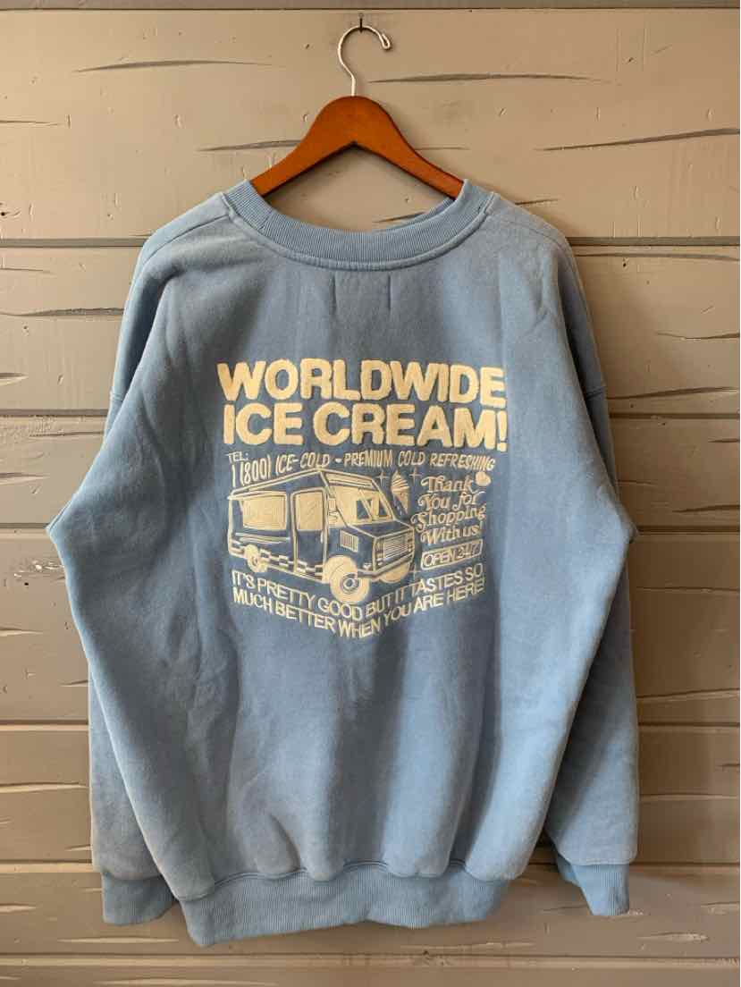 Light blue oversized sweatshirt with white vintage-style "Worldwide Ice Cream" graphic on the back.