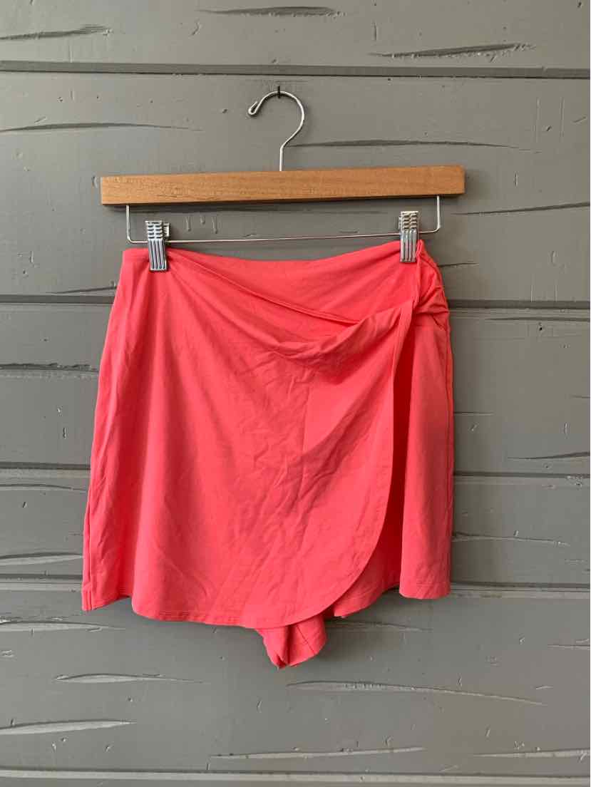 Coral pink athletic skort with wrap-front detail and lightweight fabric, size XS.