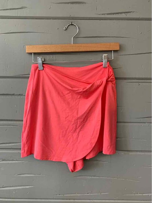 Coral pink athletic skort with wrap-front detail and lightweight fabric, size XS.