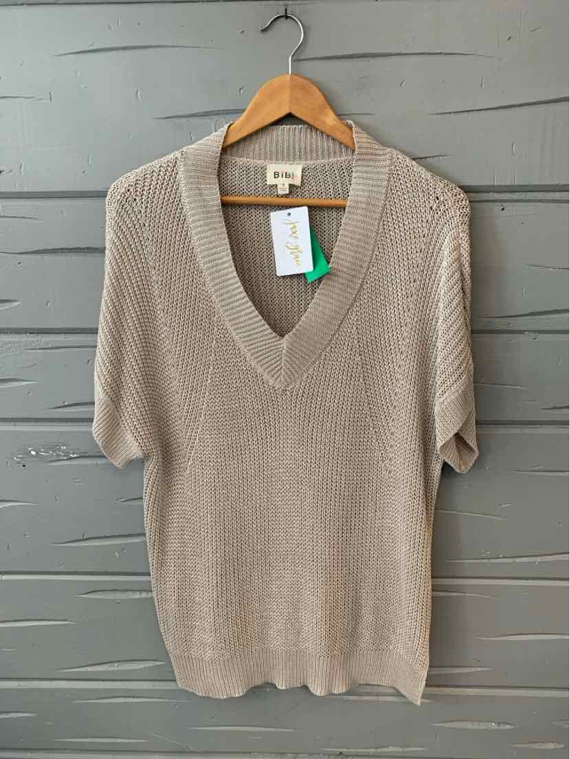 Taupe knit short-sleeve sweater with deep V-neck hanging on wooden hanger.