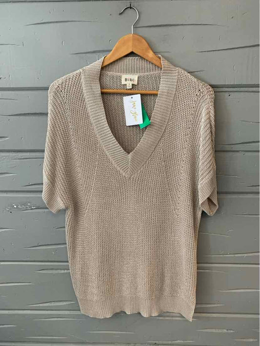 Taupe knit short-sleeve sweater with deep V-neck hanging on wooden hanger.