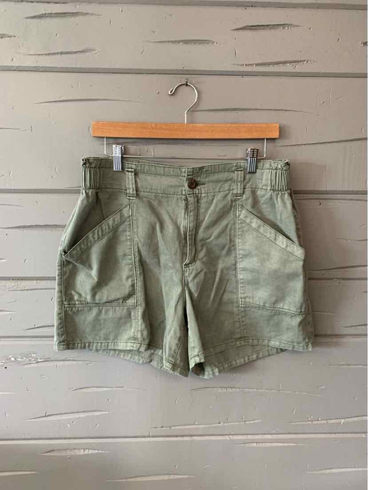 Olive green mid-length cotton shorts with front patch pockets and button closure.