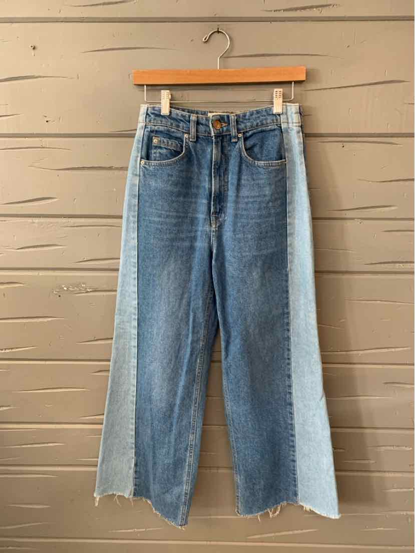 Two-tone denim jeans with wide legs, light blue front panel, darker blue back panel, raw hem edges, and classic five-pocket.