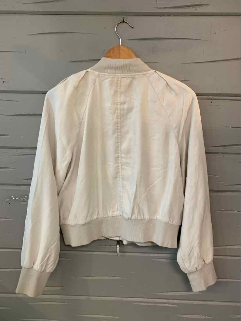 Light beige long-sleeve jacket with ribbed cuffs and hem, lightweight fabric, relaxed fit.