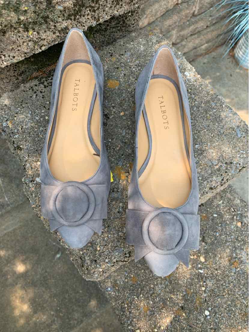 Gray suede pointed-toe flats with a decorative circular buckle on the toe and low heels.