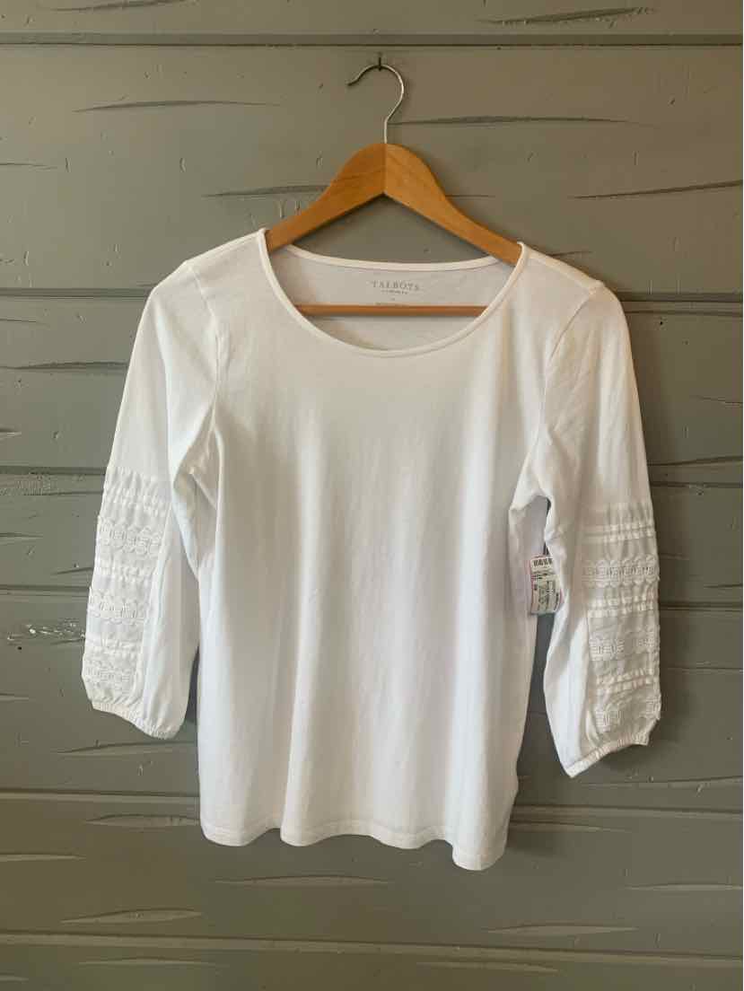 White scoop neck blouse with three-quarter ruched sleeves on wooden hanger against gray wall.