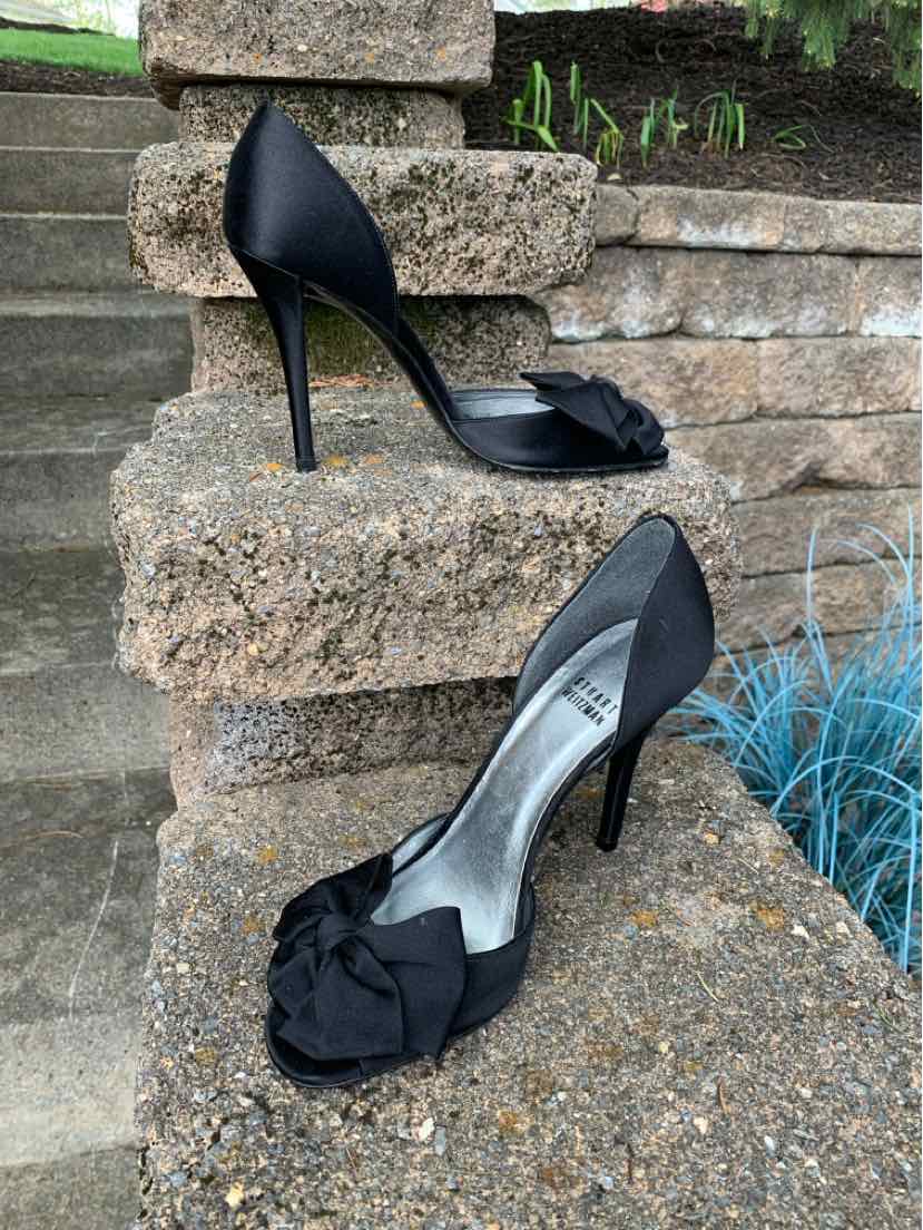 Black satin high-heeled pumps with peep toe and floral embellishment at front in size 7.5.